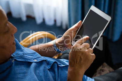 View of senior man using digital tablet at nursing home
