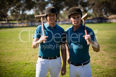 Two male jockeys standing in the ranch