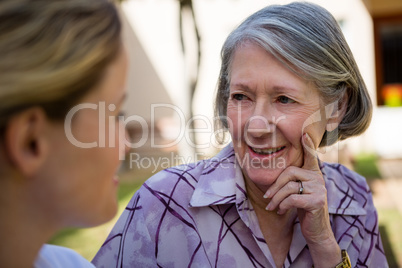 Senior woman talking to doctor at yard