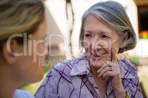 Senior woman talking to doctor at yard