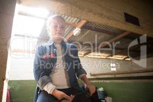 Girl sitting in stable