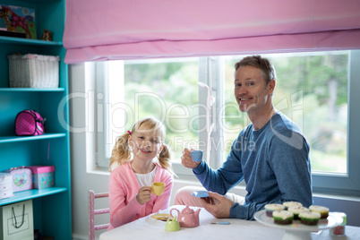 Father and daughter playing a tea set role play