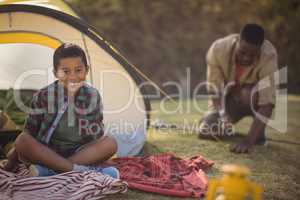 Smiling boy sitting in tent