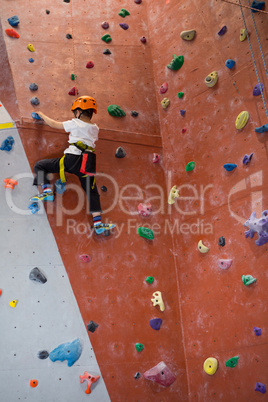 Determined boy practicing rock climbing