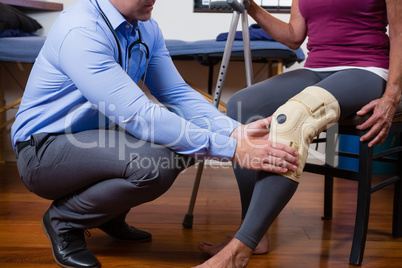 Physiotherapist examining his patients knee