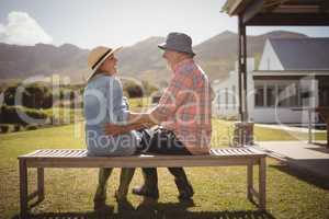 Senior couple looking at each other while sitting on a bench