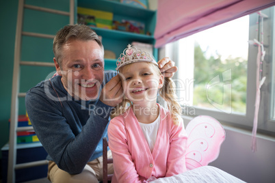 Father putting a tiera on daughters head