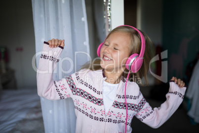 Girl listening to music on headphones at home