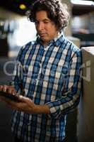 Man using digital tablet in the stable