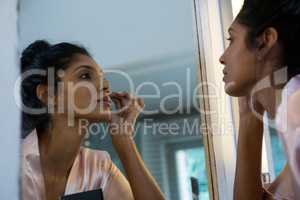 Woman applying makeup reflecting on mirror