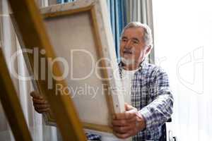 Senior man looking at painting while sitting on wheelchair