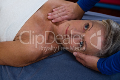 Senior woman receiving massage from physiotherapist
