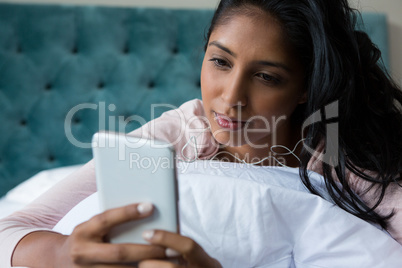 Woman using phone on bed