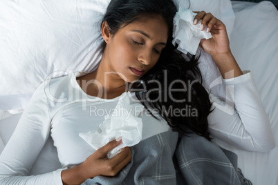 High angle view of sick woman sleeping on bed