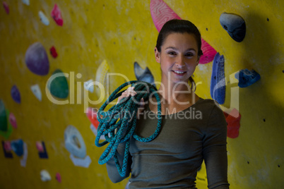 Happy woman with rope in fitness studio