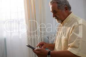 Senior man using digital tablet in retirement home