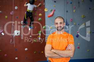 Trainer standing with arms crossed in fitness studio