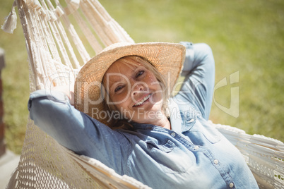 Smiling senior woman relaxing on hammock