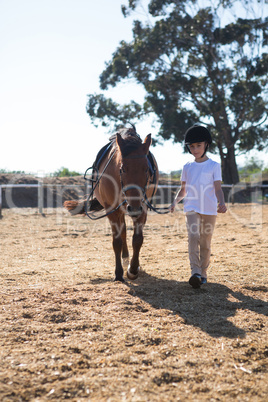 Rider girl walking with a horse in the ranch