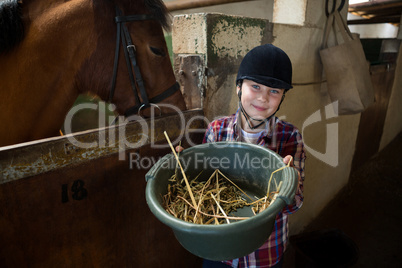 Girl feeding the horse in the stable