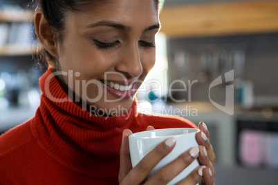 Smiling young woman having coffee