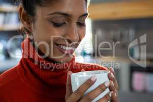 Smiling young woman having coffee
