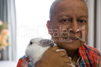 Portrait of senior man holding rabbit at nursing home