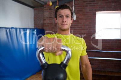 Portrait of confident man holding kettlebell