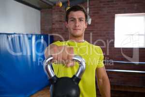 Portrait of confident man holding kettlebell