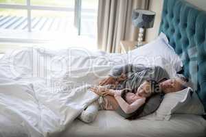 Father and daughter sleeping together on bed in bedroom