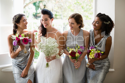 Bride and bridesmaids standing with bouquet