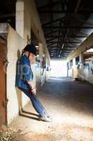 Girl leaning on wall in the stable