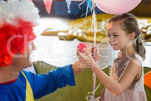 Clown and girl interacting with each other during birthday party