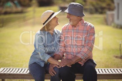 Senior couple looking at each other while sitting on a bench