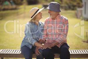Senior couple looking at each other while sitting on a bench