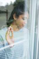Woman with eyes closed seen through glass