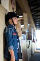 Girl leaning on wall in the stable