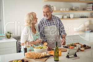 Senior couple preparing meal in kitchen