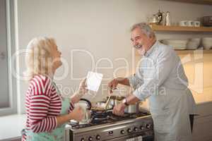 Senior couple interacting while preparing food