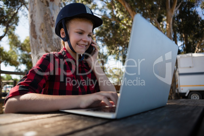 Girl talking on phone while using laptop