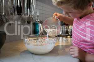 Boy pouring milk in batter