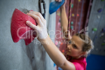 Determined teenage girl practicing rock climbing