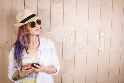 Woman posing while holding mobile phone