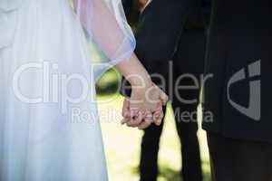 Mid section of couple holding hands