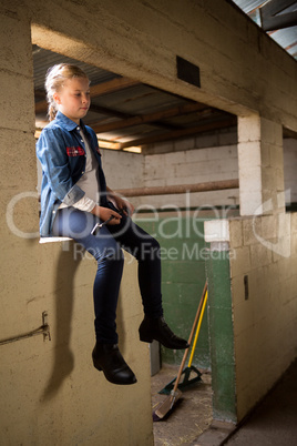 Girl sitting in stable