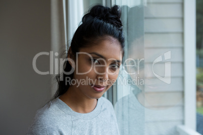 Portrait of woman by glass window