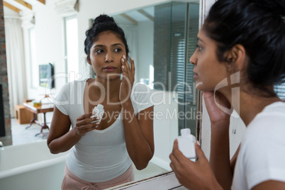 Young woman applying lotion
