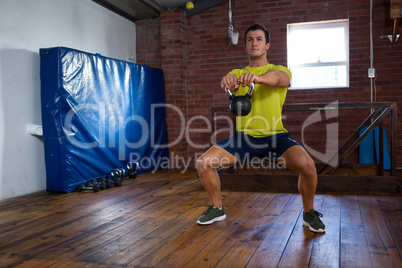 Determined man exercising with kettlebell