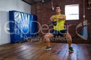 Determined man exercising with kettlebell