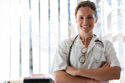 Portrait of confident female doctor with arms crossed standing in nursing home